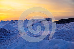 Blocks of ice on the seashore at sunset