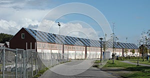 Blocks of terraced houses with solar panels on the roof, under construction and placed in a circular line