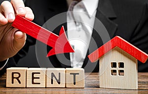 Blocks with the word Rent, down arrow and a miniature house. The concept of reducing the price of renting a house or apartment.
