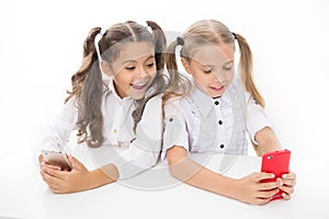 Blog for students. Little children typing new blog post from smartphone. Small bloggers keeping class blog. Smart girls