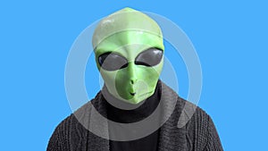 Blogger in funny alien costume and home outfit sits in front of camera to record video to create interesting