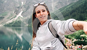 Blogger girl. Young female travel photographer with smartphone on summer mountain rock nature background. Freedom