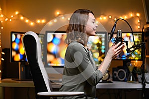 A blogger is recording a podcast with a microphone and computers in the background. Blogging and podcasts, recording on YouTube