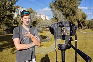 A blogger records a video tutorial in the park on camera. blogging concept. Vlog, remote work