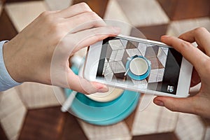 Blogger takes pictures of coffee on table in cafe