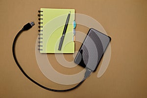 Blogging, blog and blogger or social media concept: notepad and an external hard drive on the background. Flat lay