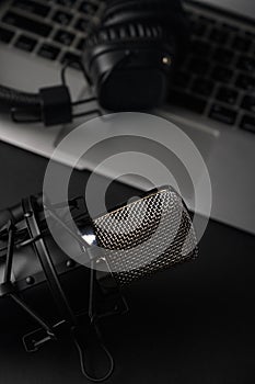 Blogging, podcasts, streams and broadcast, background. Black studio microphone on a laptop on a black background