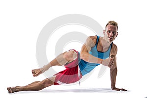 Blond athletic young man exercizing on the floor