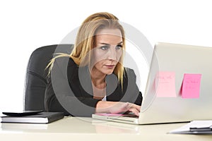 Blond attractive 40s woman in business suit working at laptop co