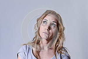 Blond attractive woman on her thirties sad and depressed looking desperate in sorrow