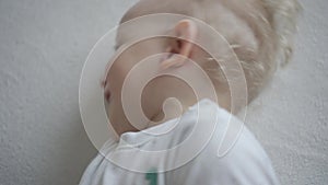 Blond baby boy laugh while someone tickle him. Gimbal motion