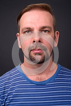 Blond bearded man with goatee against gray background