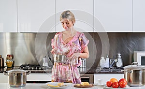 Blond beautiful sexy girl with cooking pot in kitchen doing breakfast with healthy food. Morning of pretty woman