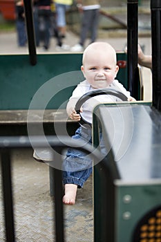 Blond boy driving a toy car