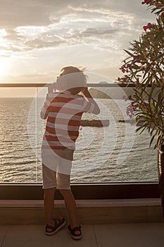 blond boy looks thoughtfully into the distance at the sea standi