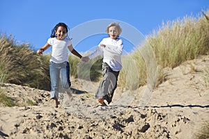 Blond Boy & Mixed Race Girl Running At Beach