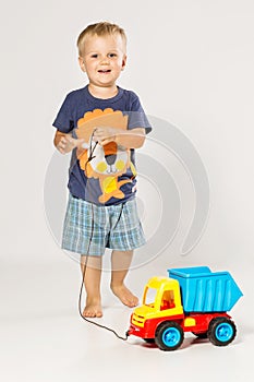 Blond Boy playing with the small plastic car