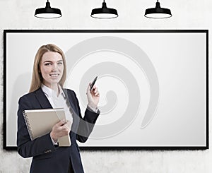 Blond business coach with marker, blank whiteboard