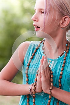 Blond caucasian girl in namaste. girl hands in namaste gesture outdoor summer day. yoga, mindfulness, harmony concept - girl