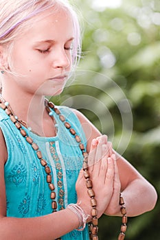 Blond caucasian girl in namaste. girl hands in namaste gesture outdoor summer day. yoga, mindfulness, harmony concept - girl