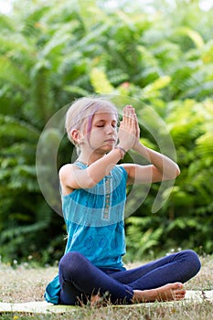 Blond caucasian girl in namaste. girl hands in namaste gesture outdoor summer day. yoga, mindfulness, harmony concept - girl