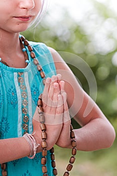 Blond caucasian girl in namaste. girl hands in namaste gesture outdoor summer day. yoga, mindfulness, harmony concept - girl