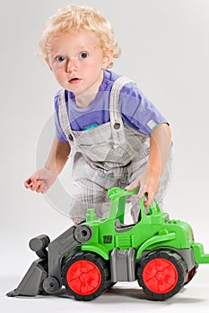 Blond child plays with tractor