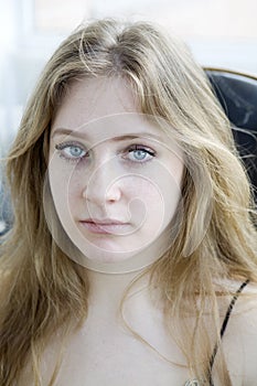 Blond crying teen girl with long hair and blue eye