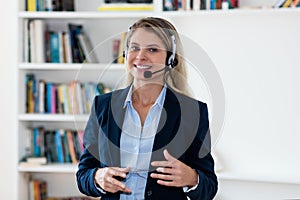 Blond customer support female agent with headphones