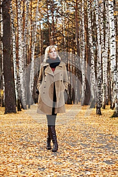 Blond fashion woman walking in autumn forest