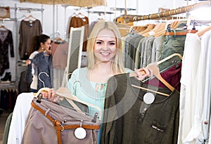 Blond female customer selecting new garments