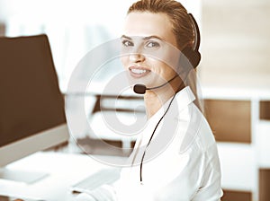 Blond female customer service representative is consulting clients online using headset. Call center and business