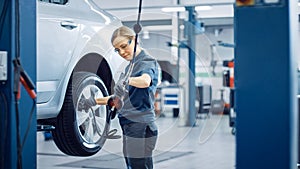 Blond Female Mechanic is Checing the Tire Pressure in a Wheel of a Vehicle. Empowering Woman Works
