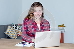 Blond female student with computer looking at camera