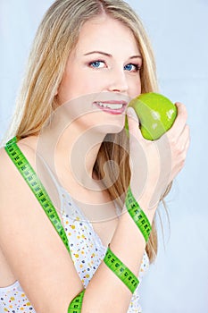 Blond girl with apple and measuring tape