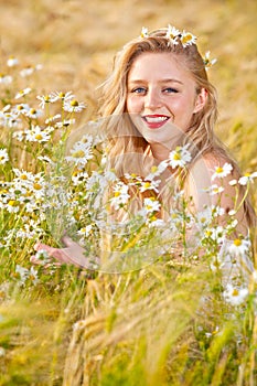 Blond girl on the camomile field