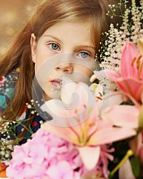 Blond girl close up portrait with lily bouquet
