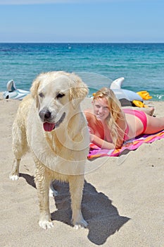 Blond girl with dog on the beach