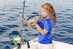 Blond girl fishing bluefin tuna trolling sea