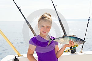 Blond girl fishing bonito Sarda tuna trolling sea