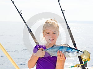 Blond girl fishing bonito Sarda tuna trolling sea photo