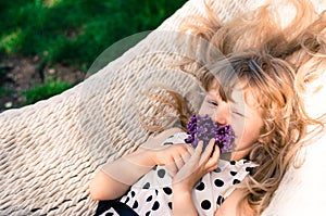 Blond girl in hammock with flowers