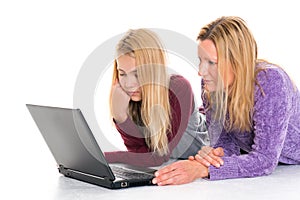 Blond girl and her mother using laptop