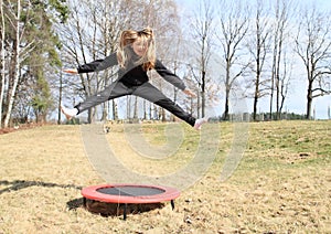 Blond girl jumping on trampoline