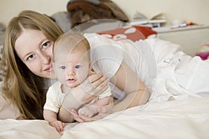 Blond girl lying on mother hands