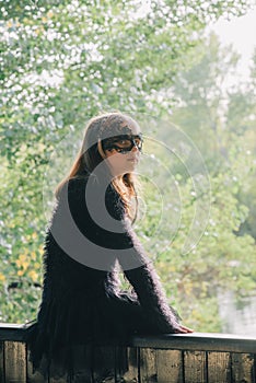 Blond girl outdoors. Halloween. Teenage girl in park. Girl in a masquerade mask/ Portrait of a beautiful girl teenager