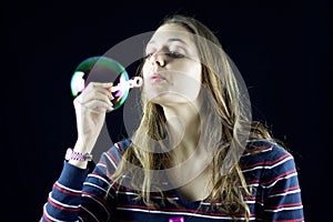 Blond girl playing with soap bubbles