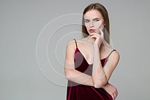 Blond girl in red poses showing emotions: wistfulness, dreaminess, muse photo