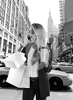 Blond girl shopaholic talking phone fifth avenue NY