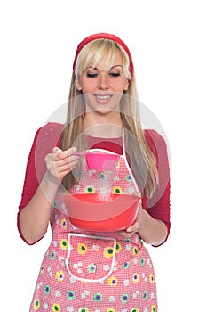 Blond girl sieving flour in to dish